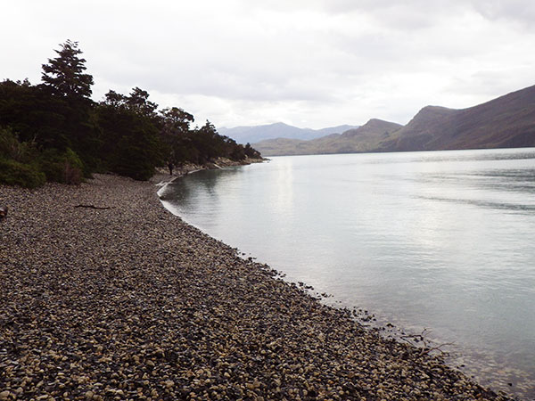Um trecho da trilha é nessa praia de pedrinhas na beira do lago; o tempo fechou ainda mais - Circuito W, Torres del Paine, Chile - Foto: Janaina Vieira.