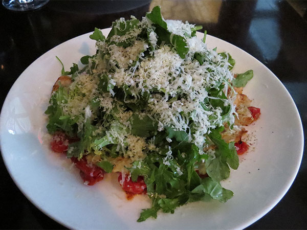 Prato principal: filé de frango grellhado (grilled chicken Paillard shaved parmesan, tomato confit, arugula salad and sherry vinaigrette) do Restaurante Madison & Vine em Manhattan, New York